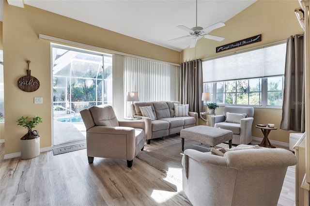 living room featuring ceiling fan, light hardwood / wood-style floors, and lofted ceiling