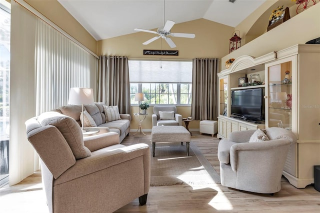 living room with ceiling fan, light wood-type flooring, and lofted ceiling