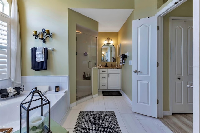 bathroom with tile patterned floors, independent shower and bath, and vanity