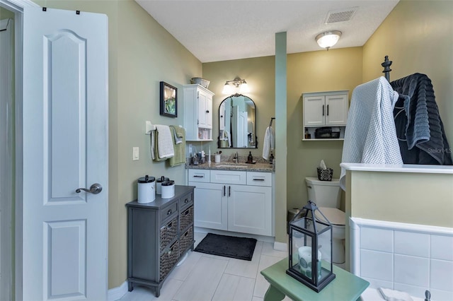 bathroom with a textured ceiling, vanity, and tile patterned floors