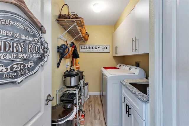 clothes washing area featuring independent washer and dryer, cabinets, and light wood-type flooring