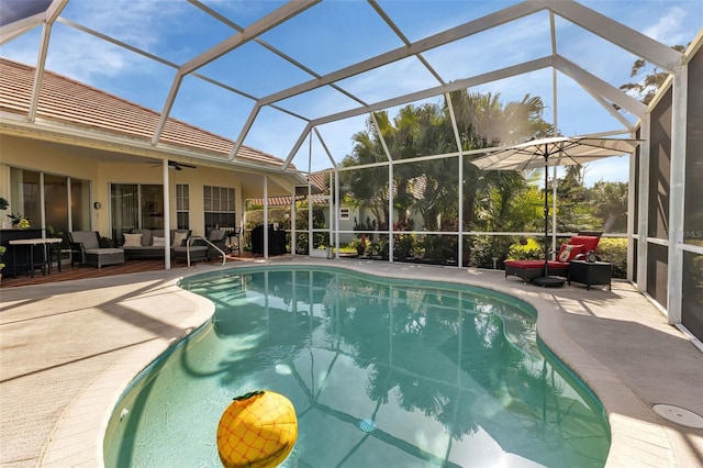 view of pool with ceiling fan, an outdoor hangout area, a patio area, and a lanai