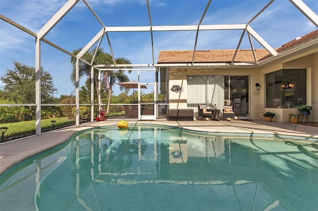 view of swimming pool featuring glass enclosure and a patio area