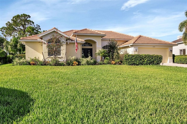 mediterranean / spanish-style house with a garage, a front yard, and stucco siding