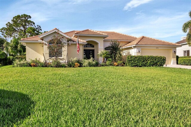 13791 Palmetto Point Ct, Port Charlotte, FL 33953 - mediterranean / spanish-style house featuring stucco siding, an attached garage, and a front lawn