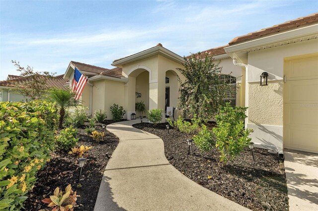 13791 Palmetto Point Ct, Port Charlotte, FL 33953 - entrance to property featuring a garage and stucco siding
