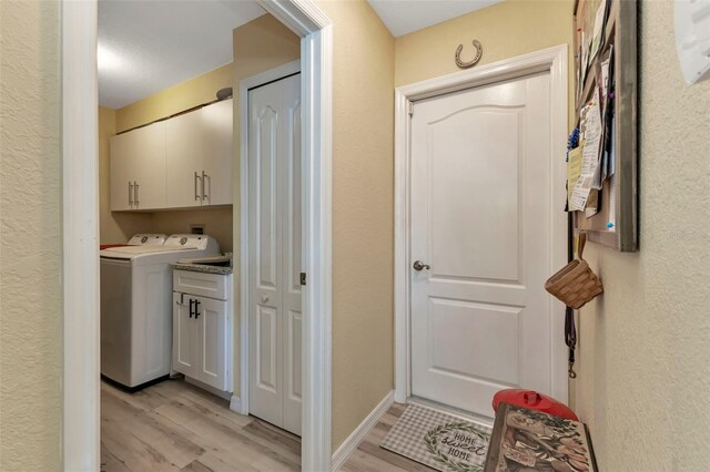 13791 Palmetto Point Ct, Port Charlotte, FL 33953 - washroom featuring washer / clothes dryer, light wood-style flooring, and cabinet space