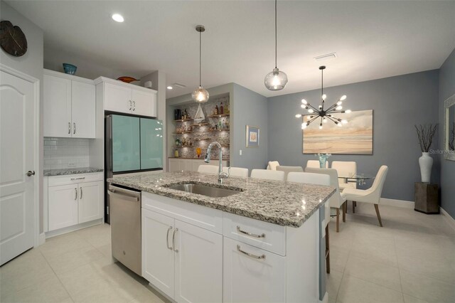 kitchen featuring decorative backsplash, sink, a center island with sink, appliances with stainless steel finishes, and light tile patterned floors