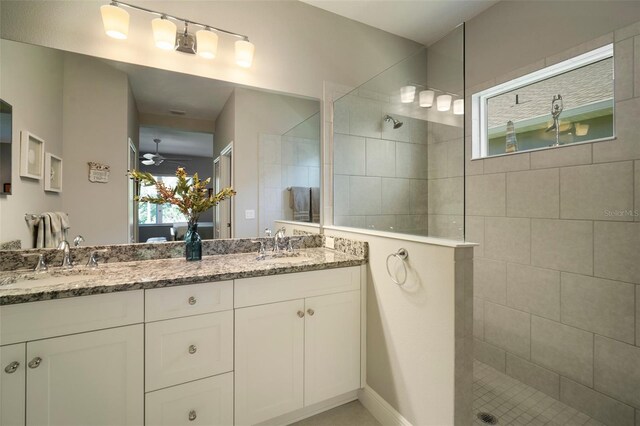 bathroom featuring dual vanity, tiled shower, and ceiling fan