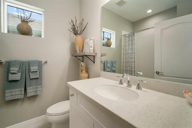 bathroom with vanity, toilet, and a wealth of natural light