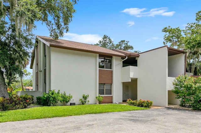 view of front facade with a balcony and a front lawn