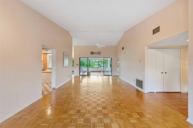 interior space with light parquet floors, ceiling fan, and high vaulted ceiling