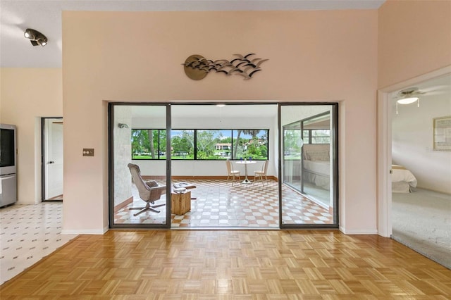 empty room with a high ceiling and light parquet flooring