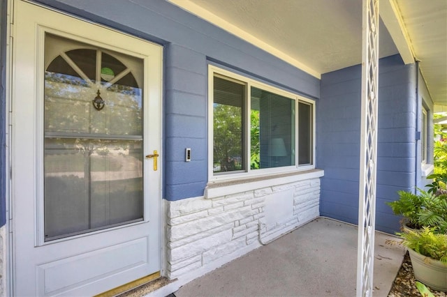 view of exterior entry featuring covered porch