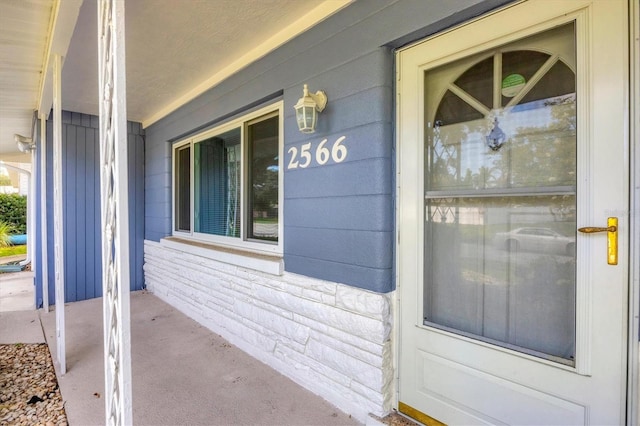 view of exterior entry with a porch