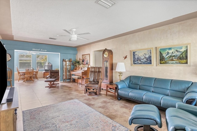 living room with light tile patterned floors, a textured ceiling, and ceiling fan