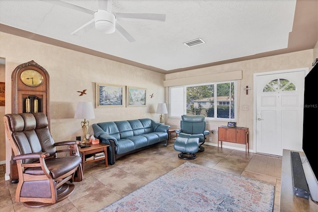 tiled living room featuring a textured ceiling and ceiling fan