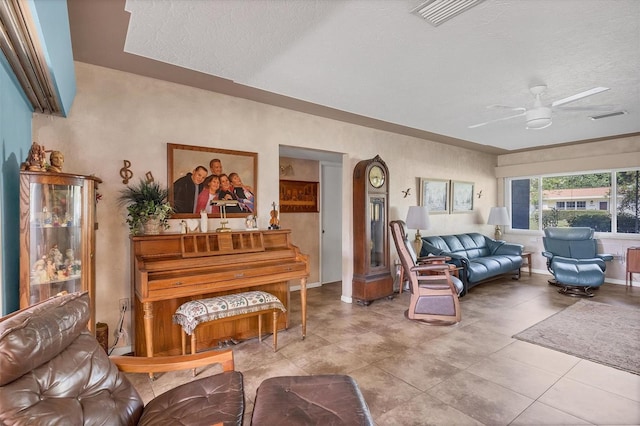 tiled living room featuring a textured ceiling and ceiling fan