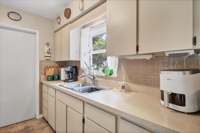 kitchen featuring light tile patterned floors, tasteful backsplash, and sink