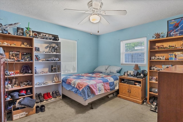 bedroom with light carpet, a textured ceiling, and ceiling fan