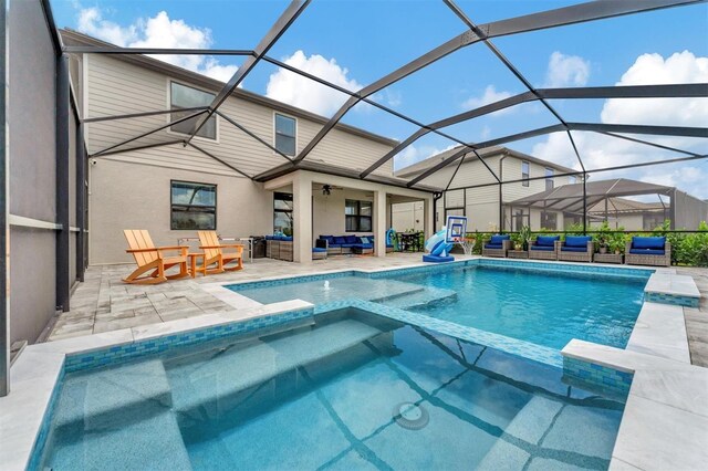 view of pool featuring an in ground hot tub, an outdoor hangout area, glass enclosure, and a patio area