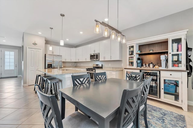 dining area with sink, light tile patterned floors, and wine cooler