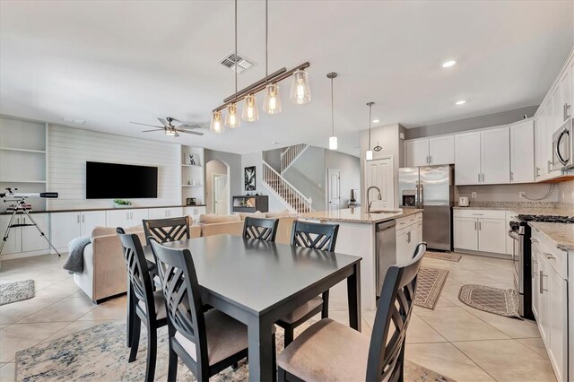 tiled dining area with sink, built in shelves, and ceiling fan