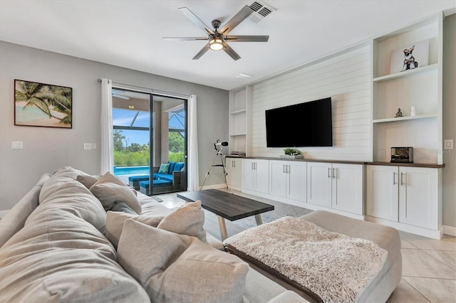 living room with light tile patterned floors, built in features, and ceiling fan