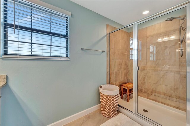 bathroom featuring a shower with door, vanity, and tile patterned floors