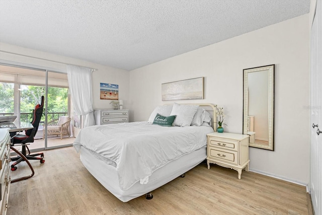 bedroom with light wood-type flooring, access to outside, baseboards, and a textured ceiling