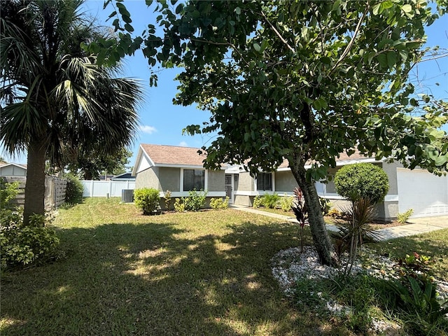 view of front facade with cooling unit and a front lawn