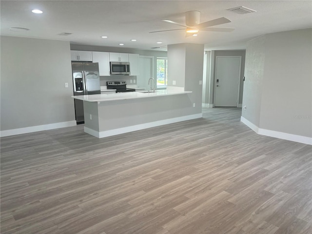 kitchen featuring stainless steel appliances, ceiling fan, sink, white cabinetry, and light hardwood / wood-style floors