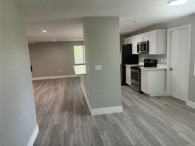 kitchen featuring light hardwood / wood-style flooring, white cabinets, and stainless steel appliances