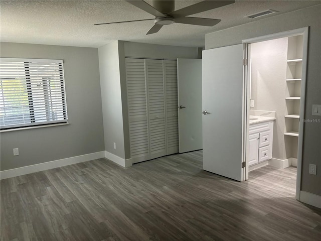 unfurnished bedroom featuring ceiling fan, wood-type flooring, a textured ceiling, and a closet