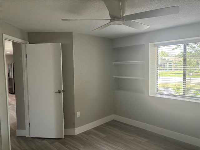 unfurnished bedroom featuring a textured ceiling, ceiling fan, and dark hardwood / wood-style flooring