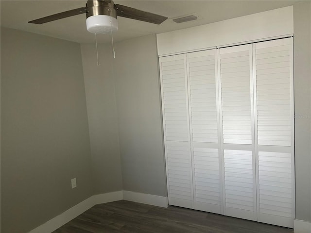 interior space featuring ceiling fan, dark wood-type flooring, and a closet