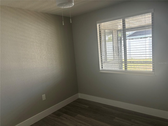 empty room with dark hardwood / wood-style flooring