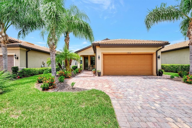 mediterranean / spanish-style home featuring a garage and a front lawn