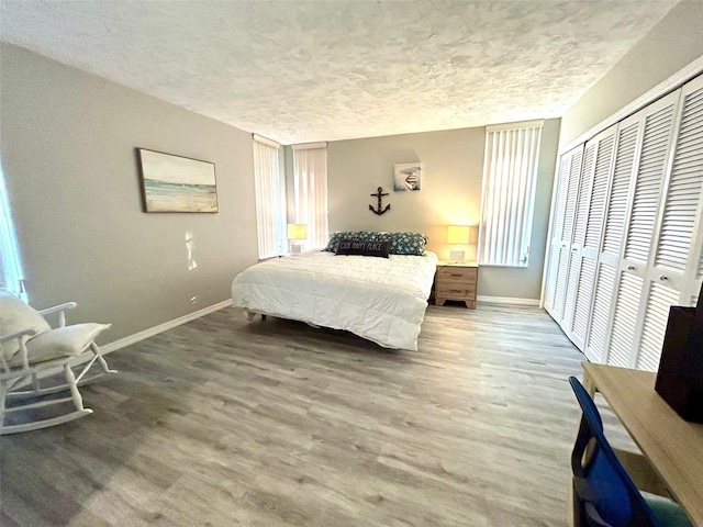 bedroom with a textured ceiling, a closet, and wood-type flooring