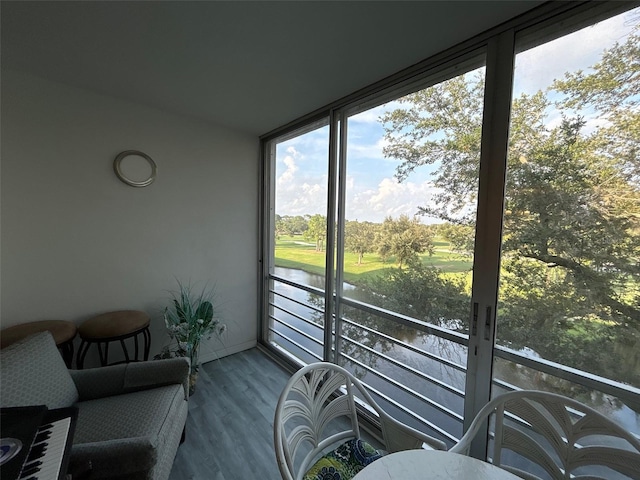 sunroom / solarium featuring a water view