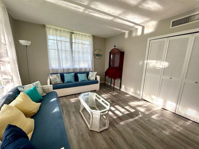 living room featuring a textured ceiling and dark wood-type flooring