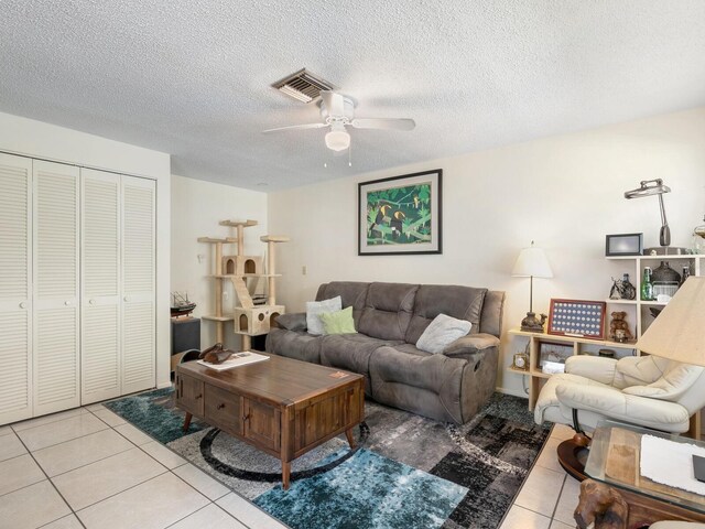 tiled living room with a textured ceiling and ceiling fan