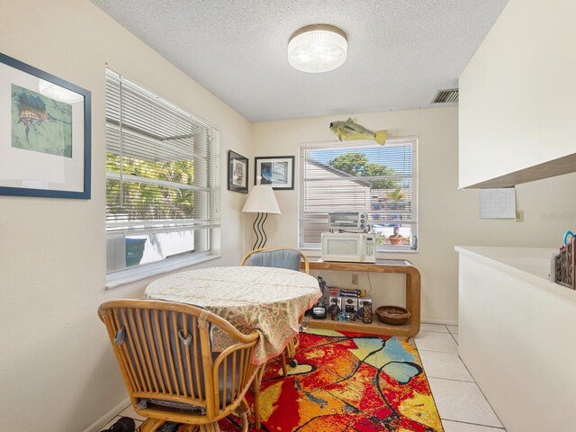 dining area with a textured ceiling and light tile patterned floors