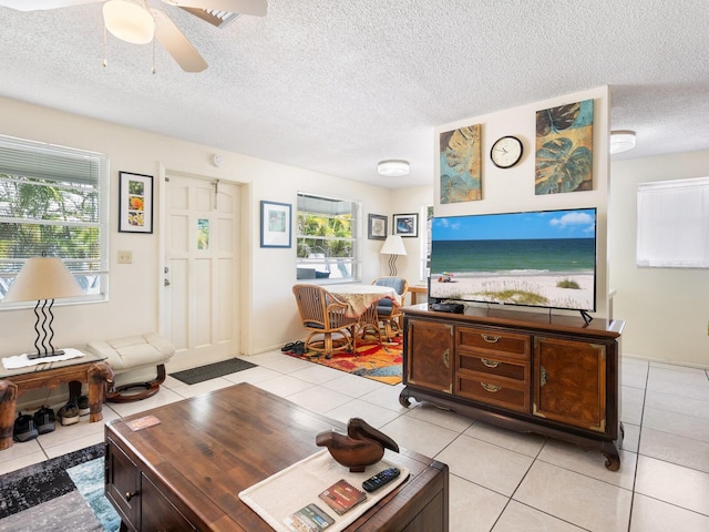 tiled living room featuring plenty of natural light, a textured ceiling, and ceiling fan