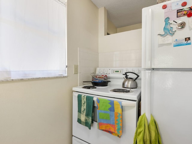 kitchen with a textured ceiling and white appliances