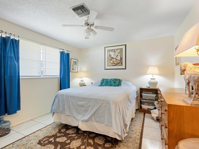 tiled bedroom featuring a textured ceiling and ceiling fan