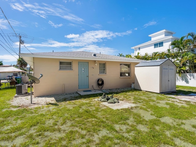 back of house featuring a storage shed, a lawn, and cooling unit