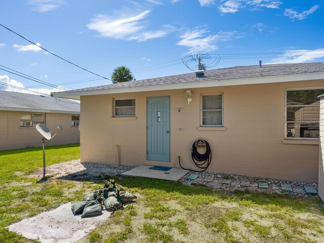 doorway to property with a lawn