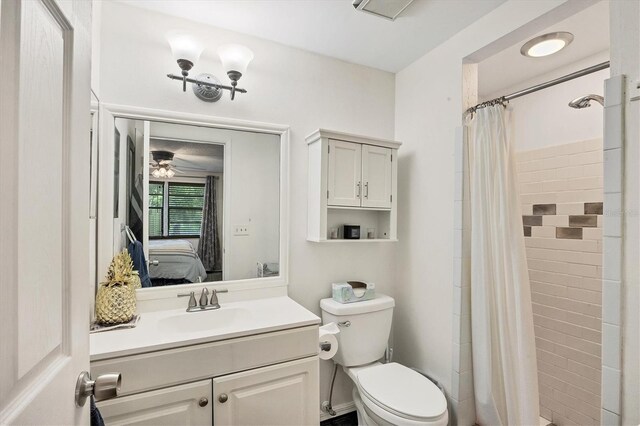 bathroom with ceiling fan, curtained shower, toilet, and vanity