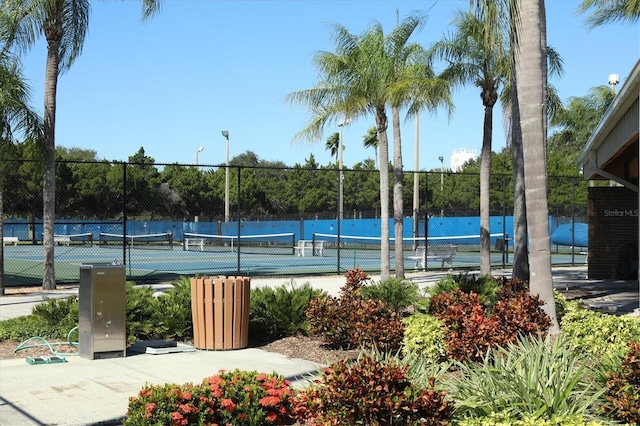 view of tennis court featuring a water view